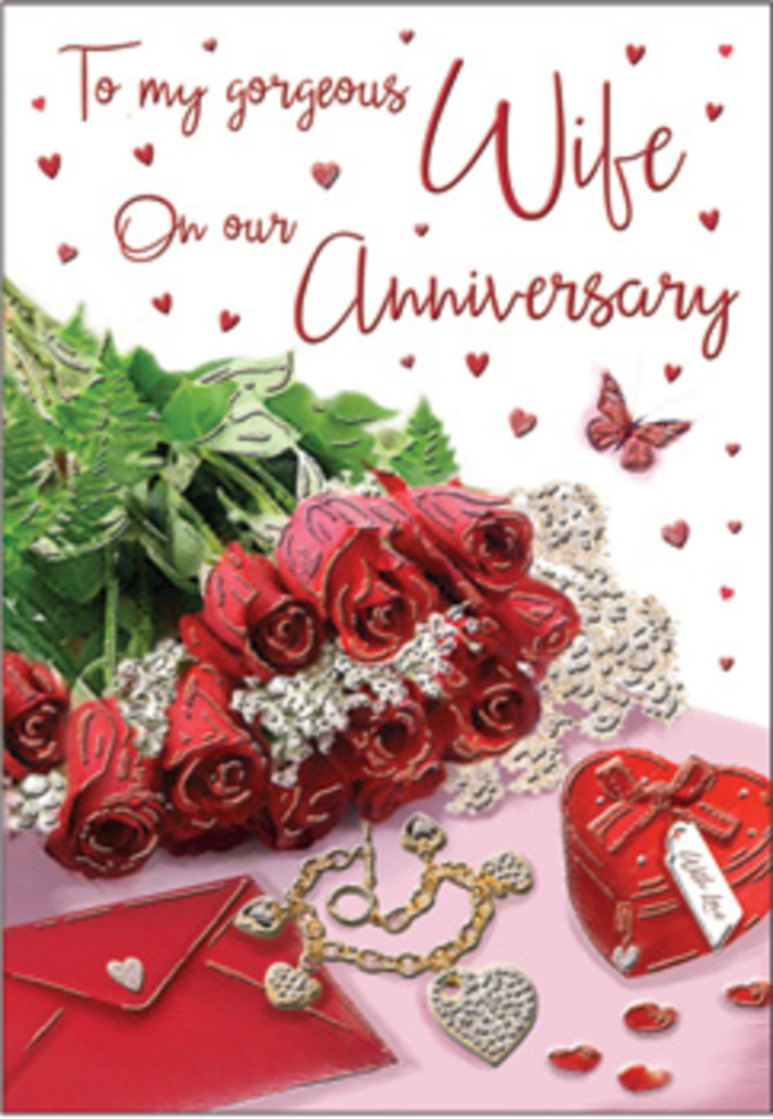 In this richly detailed anniversary scene, a bouquet of classic red roses takes centre stage, arranged with the kind of care often seen in the work of Flowers Downe. Each bloom is luxuriously full, with densely layered petals curling outward to create a deep, velvety cup of colour. The red tones range from dark, wine-like shades at the petal bases to brighter highlights along the edges, giving the flowers an almost glowing appearance in the soft light. The roses are twined with lush green foliage, whose leaves provide contrast and structure, evoking the well-tended gardens and leafy paths that surround Downe village. Around the bouquet, whisper-thin lace or delicately patterned textures draw the eye toward small heart motifs, subtly reinforcing the romantic theme. Nearby lies an elegant jewellery set, its metallic surfaces reflecting warm, gentle glints, and a vivid red box that looks ready to hold a treasured anniversary gift. The box's smooth, polished surface contrasts beautifully with the plush texture of the rose petals and the fine grain of the card beneath. Flowing, scripted text sweeps across part of the scene, its decorative curves echoing the rounded shapes of the flowers and hearts. Soft, ambient lighting casts gentle shadows that anchor each item, making the composition feel tangible and close at hand-as though placed on a table in a Downe home just before being discovered. The overall atmosphere is unmistakably romantic: a sensory blend of imagined rose fragrance, smooth fabrics, and cool metal, all coming together to honour the warmth and tenderness of a long-lasting relationship.